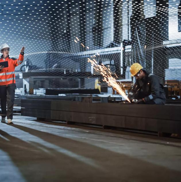 Two Heavy Industry Engineers Walk in Steel Factory, Use Tablet and Discuss Work. Industrial Worker Uses Angle Grinder in the Background. Black African American Specialist Talks to Female Technician.