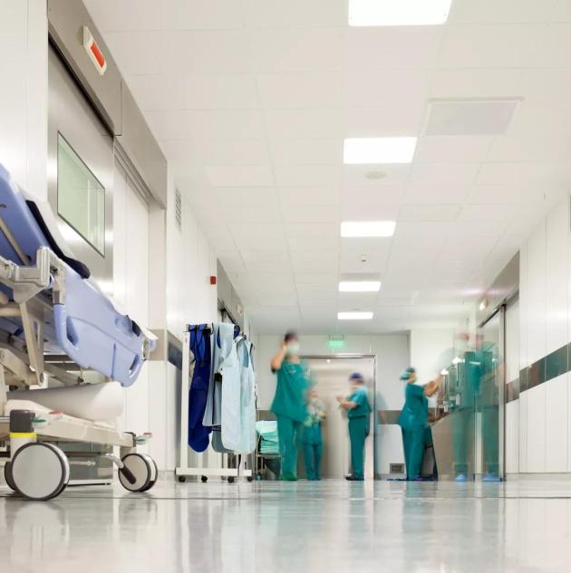 Blurred figures of people with medical uniforms in hospital corridor