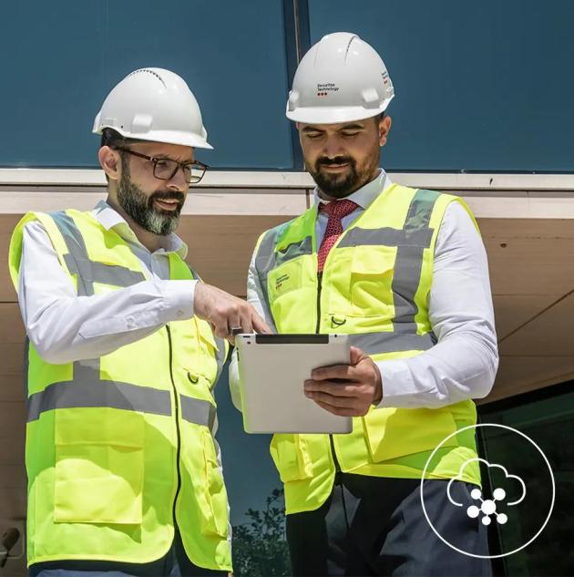 security technicians at a construction site reviewing data 