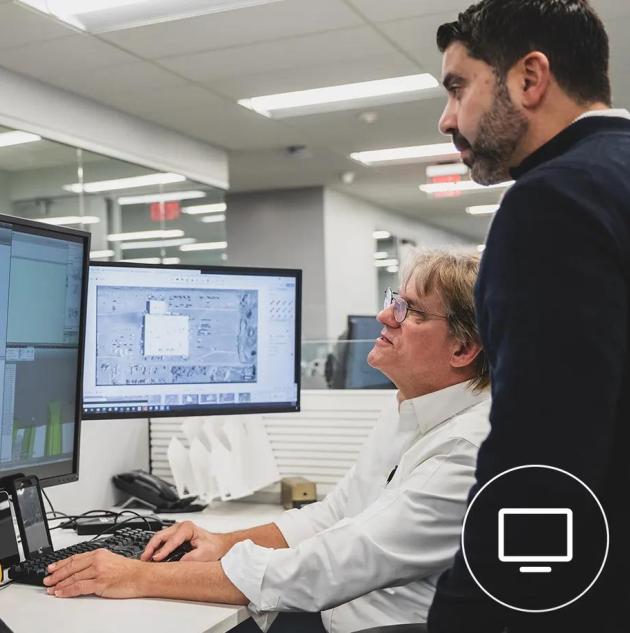 employees reviewing security system design layout plans on computer screens