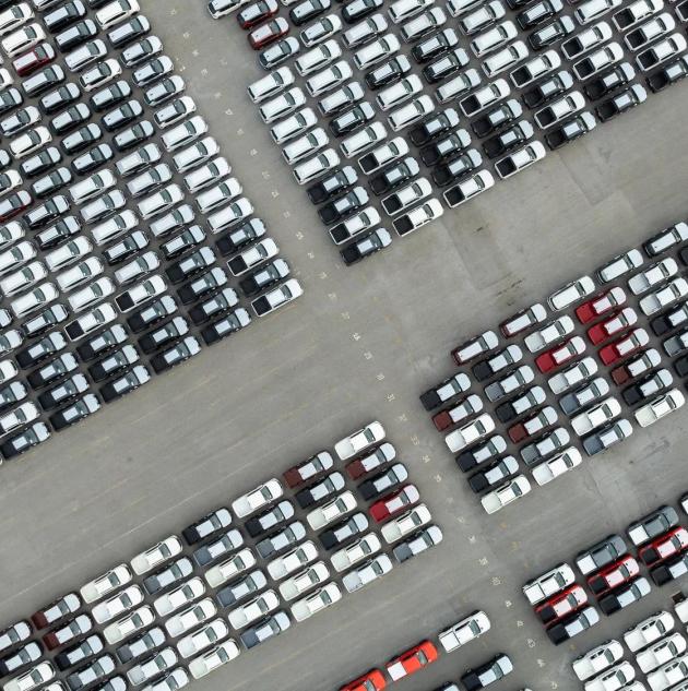 aerial top down view of a parking lot new cars lined up in the port for import and export international.